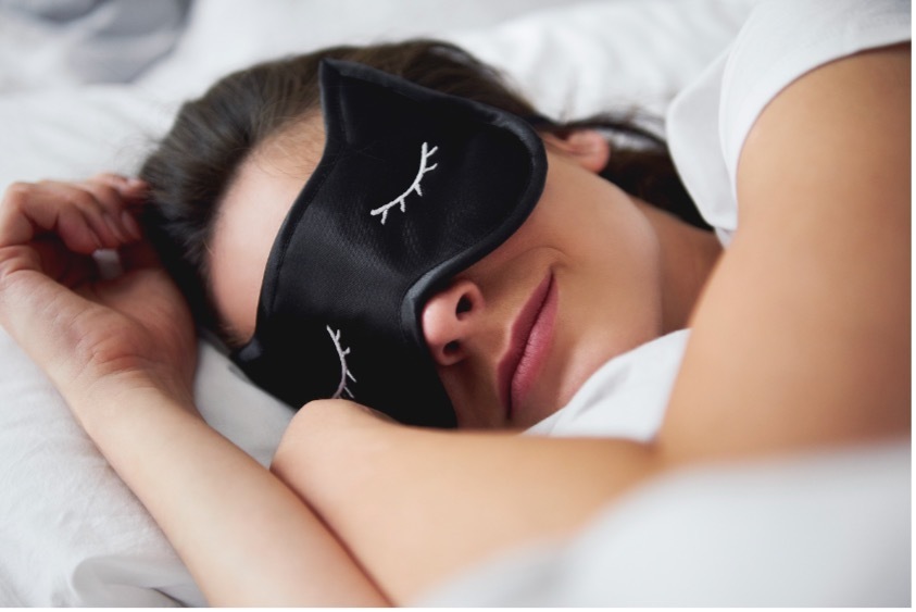 A person getting quality sleep with an eye mask, reinforcing the importance of rest for immune support and energy levels.