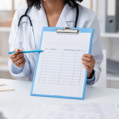 Medical provider holding a clipboard offering DOT vision screening, physical exams, weight loss support, heart health checks, and blood pressure monitoring near Albemarle and Charlotte NC at Bella Medical Associates.
